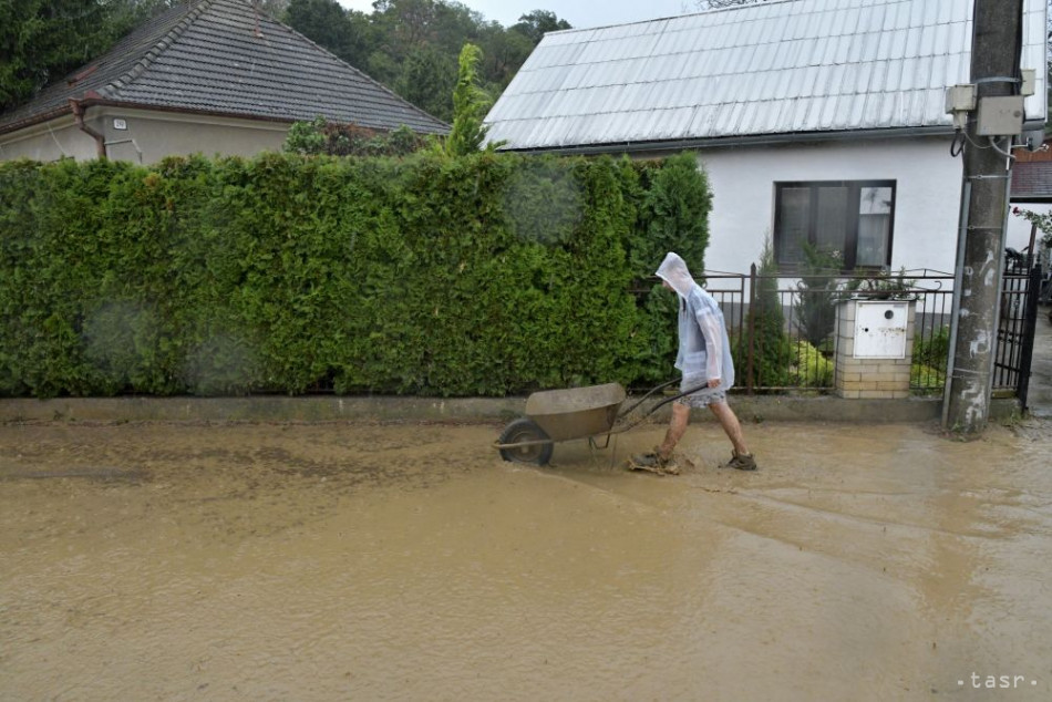 Na snímke odpratávanie vody a bahna zo zaplavenej ulice v obci Ratnovce po búrke a silnom daždi, 27. júla 2019. Foto: TASR - Martin Palkovič